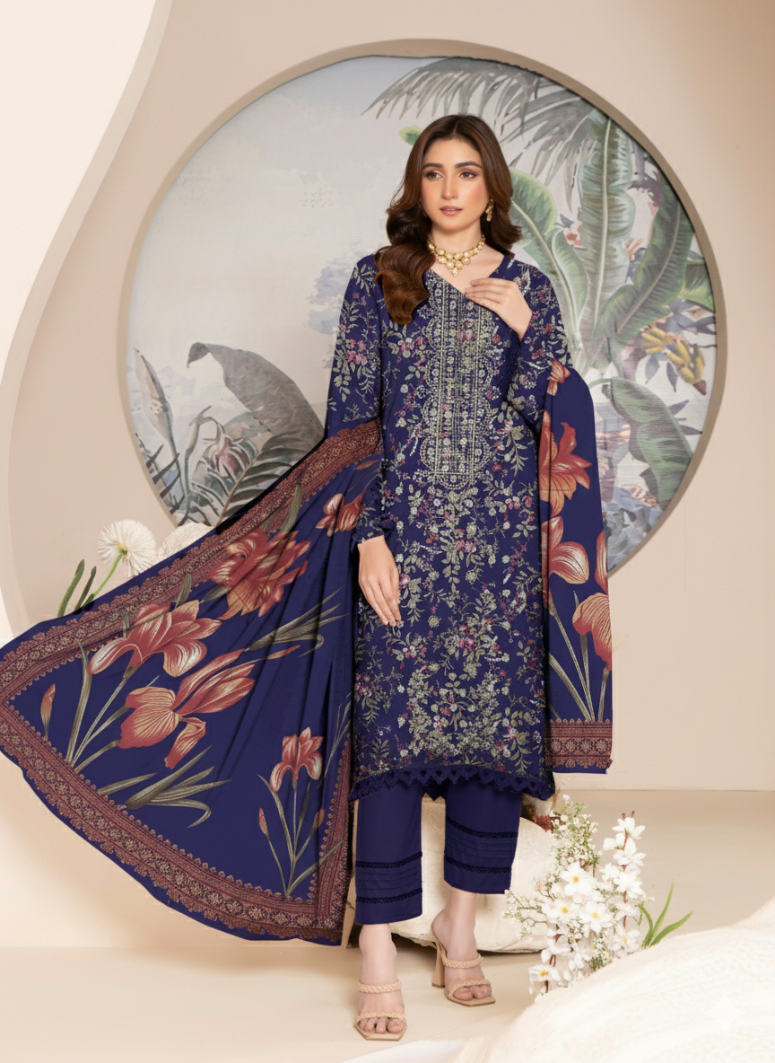Woman wearing a blue floral embroidered outfit with a matching dupatta in front of a decorative wall.