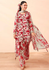 Woman wearing a red and white floral outfit with a matching dupatta on a beige background